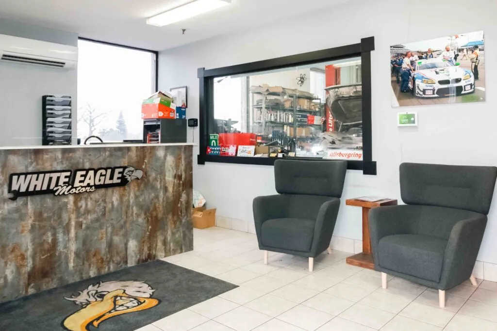 Front desk and lounge chairs, with a window into the shop